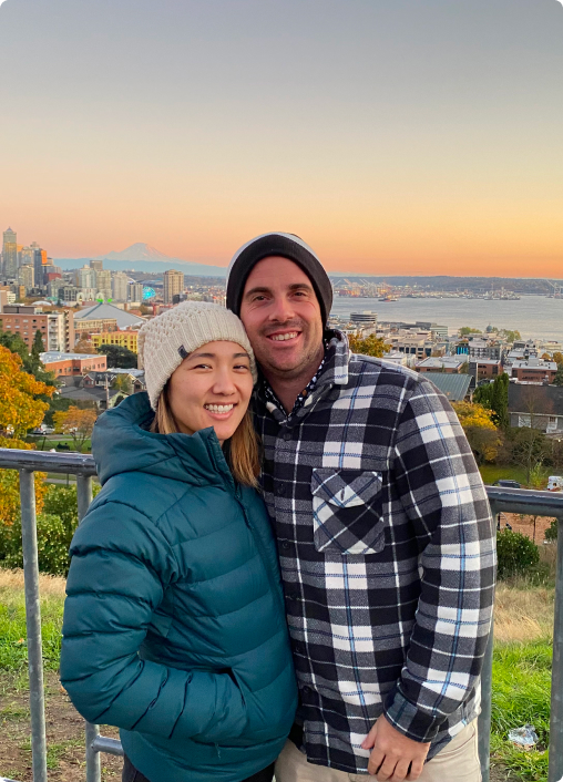 Origin Story Photo of Jack Miller with partner during sunset with city skyline in the background.